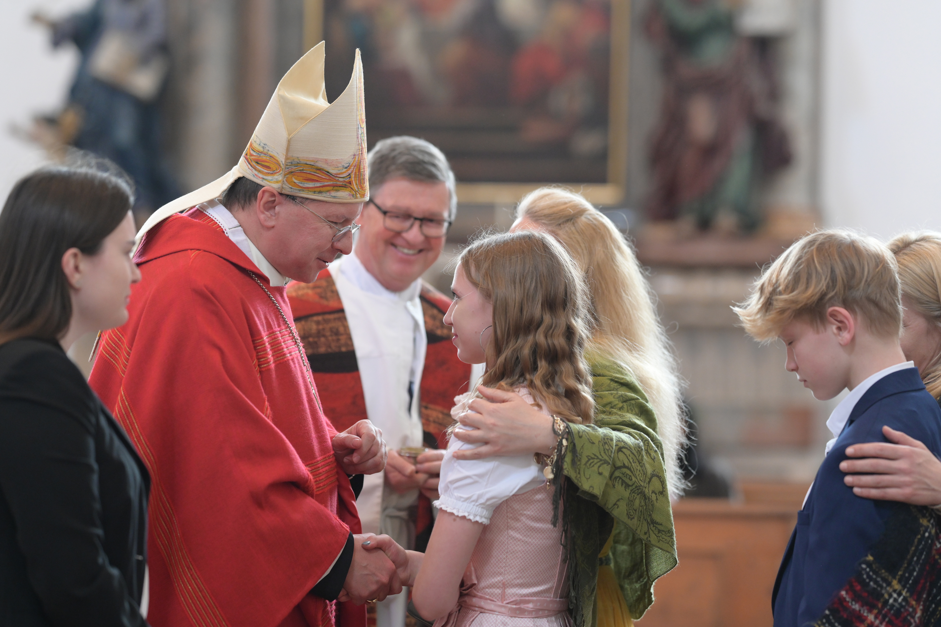 ein Bischof firmt Mädchen